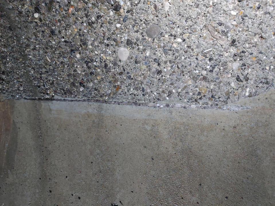 Vergleich der Oberflächen vor dem Höchstdruckstrahlen (unten) und die freigelegten Zuschlagskörner nach dem Strahlen (oben).